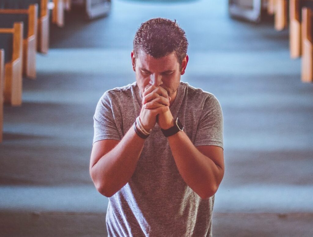 feature image of man praying in church