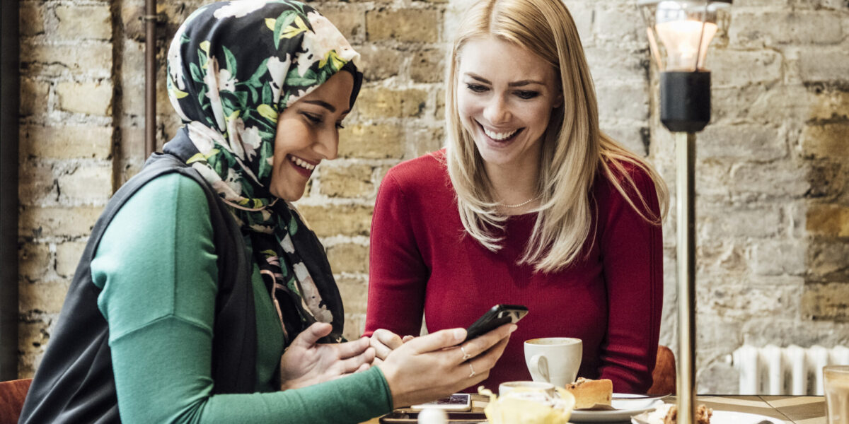 Multi racial women enjoying quality time, mid adult woman in and friend with long blond hair