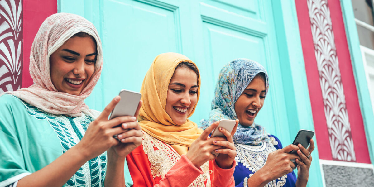 Young Muslim friend using mobile smartphones in the college - Happy Arabian girls addicted to new technology app cellphone for social media - Millennial, religion, generation z and technology concept